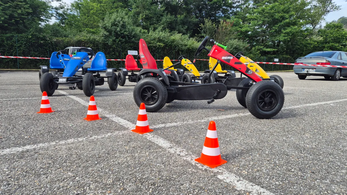 Deux participants s'affrontent sur des karts à pédales sur un circuit balisé lors d'un événement