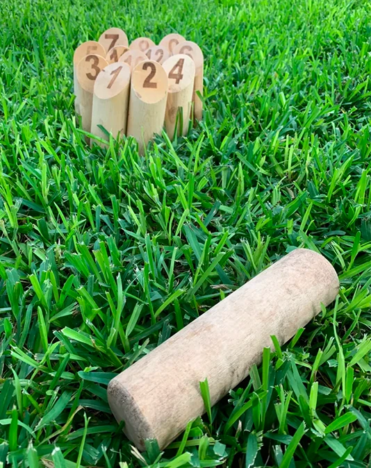 Quilles de Mölkky en configuration de départ sur gazon