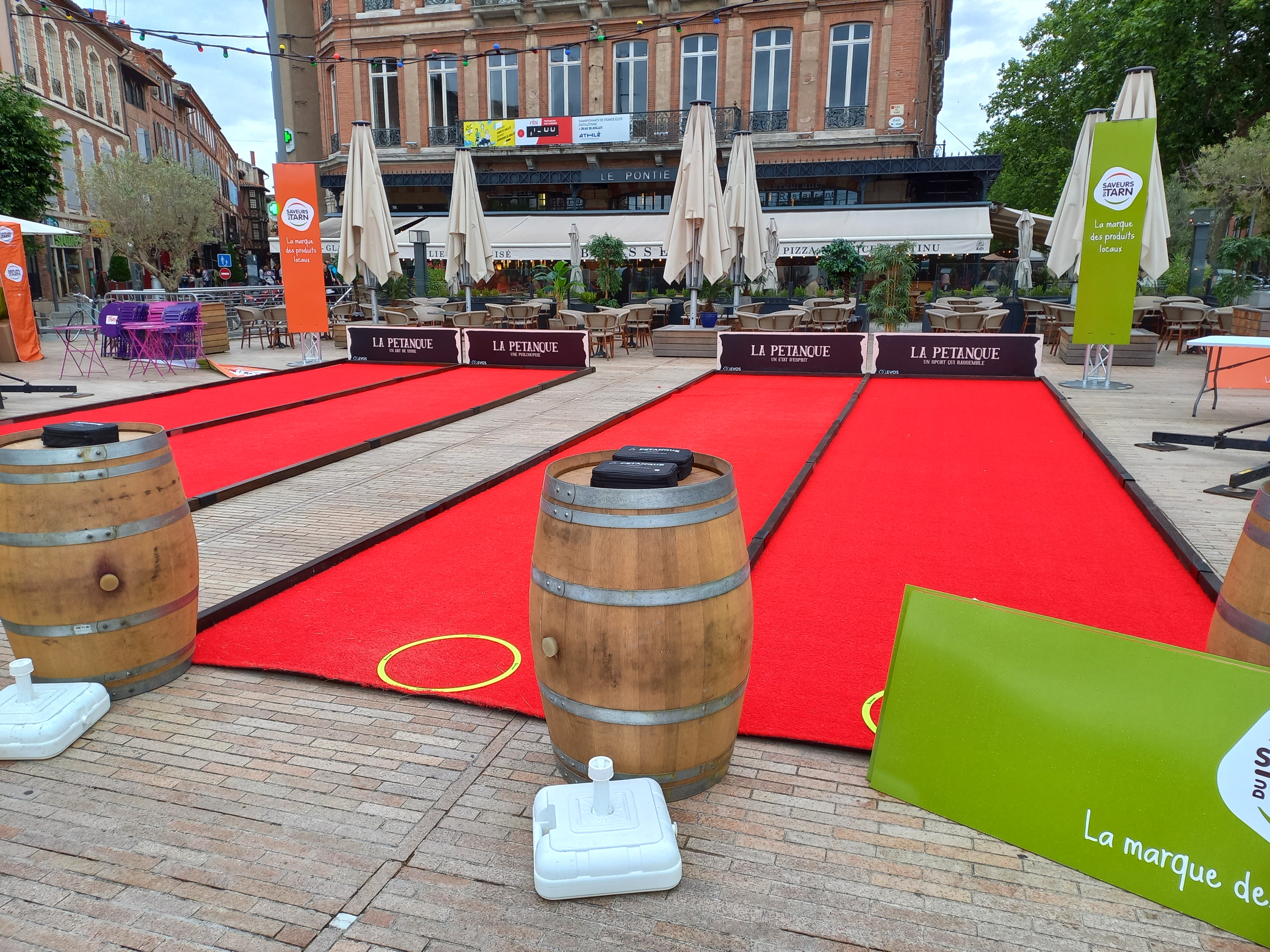 Terrain de pétanque synthétique rouge déroulé par By Anim pour une animation à Albi