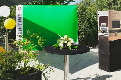 Photobooth en extérieur avec fond vert et décoration florale et ballons
