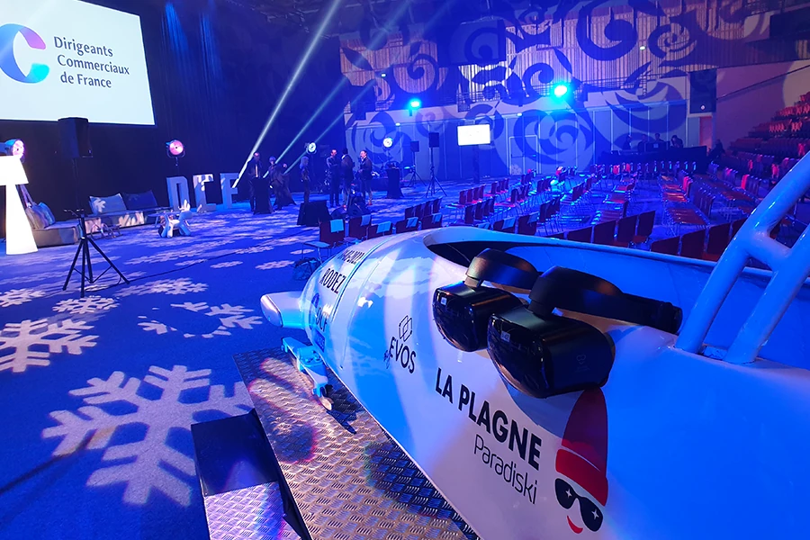 Simulateur de bobsleigh VR La Plagne dans un espace événementiel éclairé en bleu