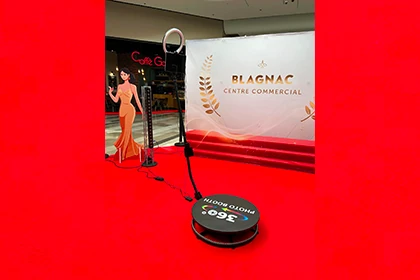 Borne photo 360 sur plateforme noire avec bras et caméra installée sur tapis rouge au centre commercial Blagnac