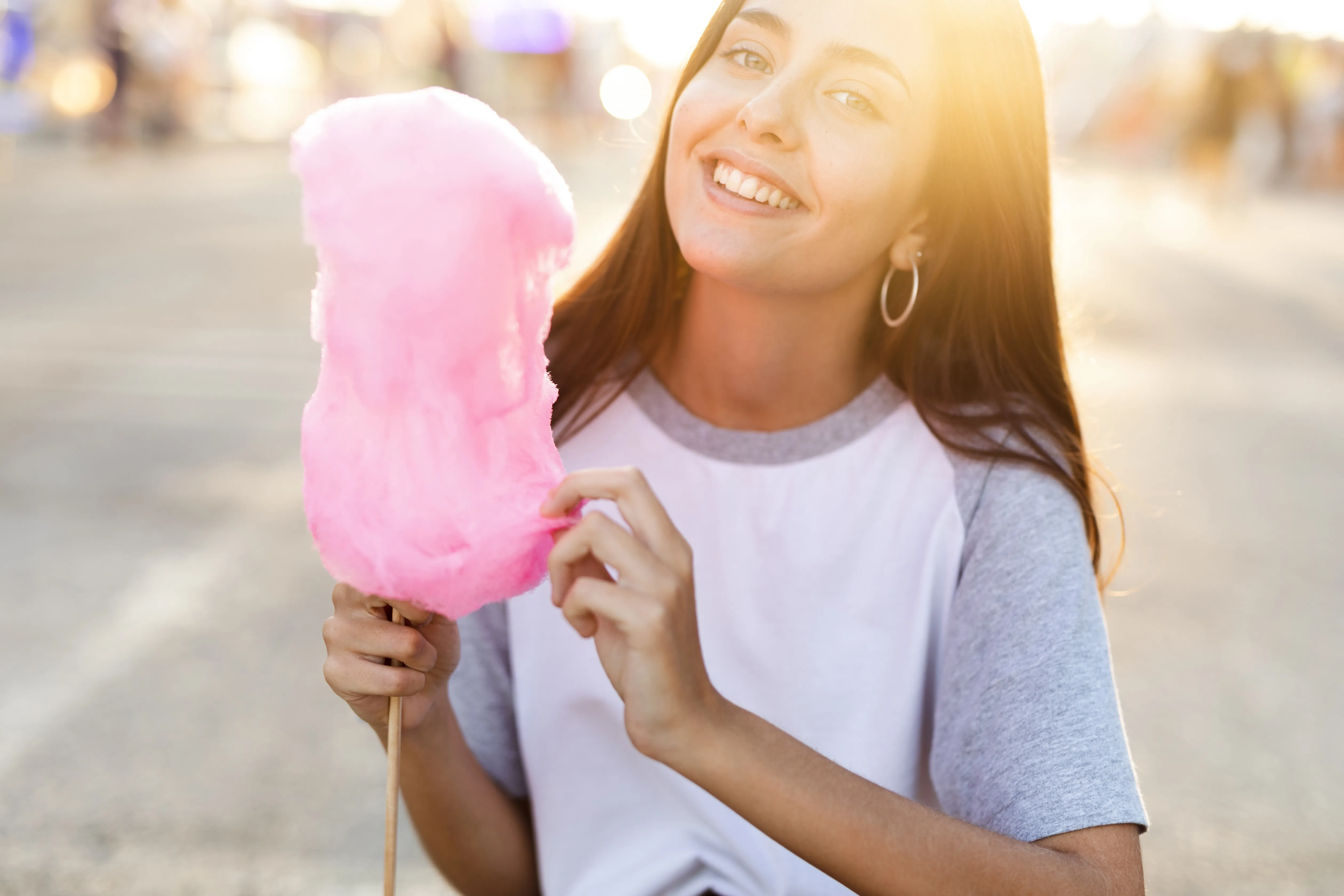 Femme dégustant une barbe à papa rose