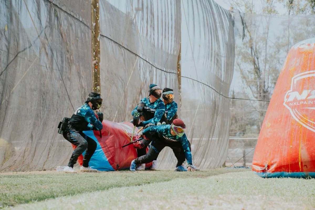 Joueurs masqués progressant en équipe derrière des obstacles gonflables lors d'un défi sportif