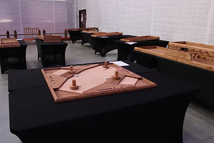 Tables de jeux en bois géants recouvertes de nappes noires dans un espace couvert