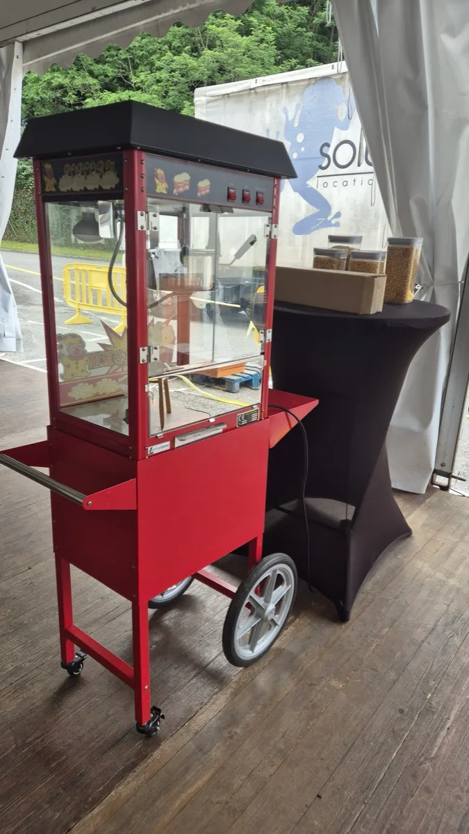 Machine à pop-corn rétro rouge sur chariot avec bocaux de maïs lors d'un événement