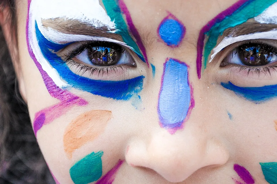Visage d'une enfant maquillé de motifs colorés