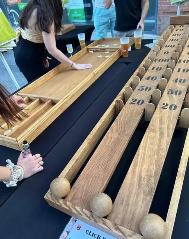 Joueurs autour de jeux en bois géants installés sur tables lors d'une animation By Anim