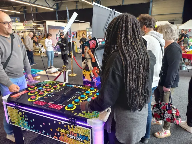 Visiteurs d'un salon jouant sur la table de réflexe lumineuse à boutons LED