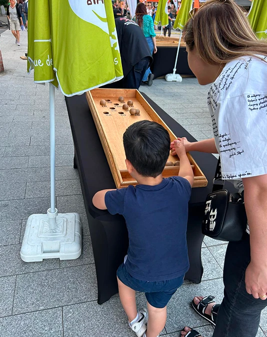 Une mère et son fils jouant à un jeu en bois en ville